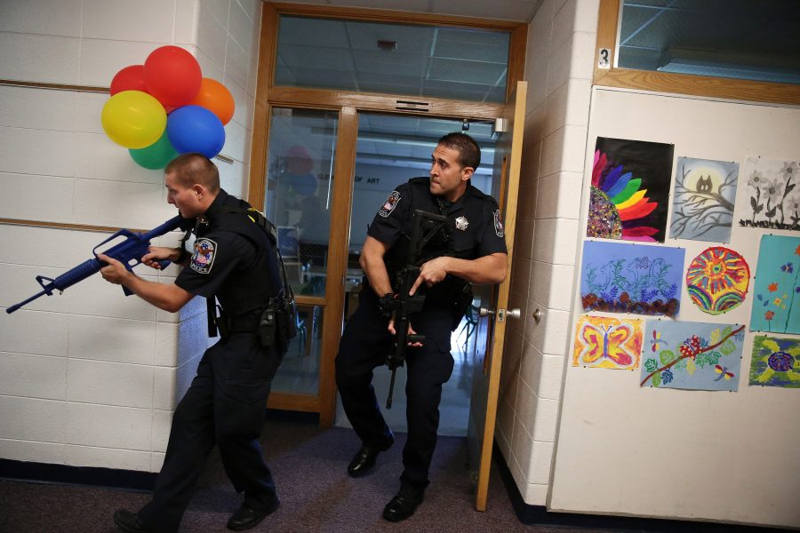 Two police officers carry blank weapons as they participate in an active shooter exercise with police, emergency workers, teachers and administrators at Oak Knoll School in Cary, Ill., on Sept. 12, 2015. (Anthony Souffle/Chicago Tribune/TNS)
