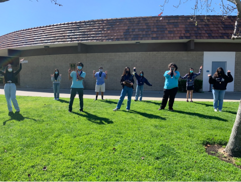 The Academic Decathlon team celebrates their regional competition win on the front lawn of the administration building, abiding by COVID guidelines.