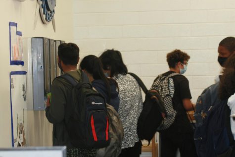 Students pick up utensils and napkins after purchasing their food in the cafeteria.
