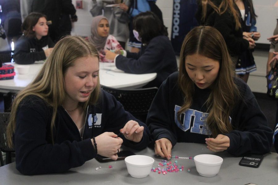 Students make friendship bracelets in the MPR.