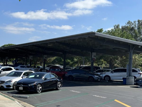 The University High School south parking lot during the school day with cars parked and built-in solar panels.
