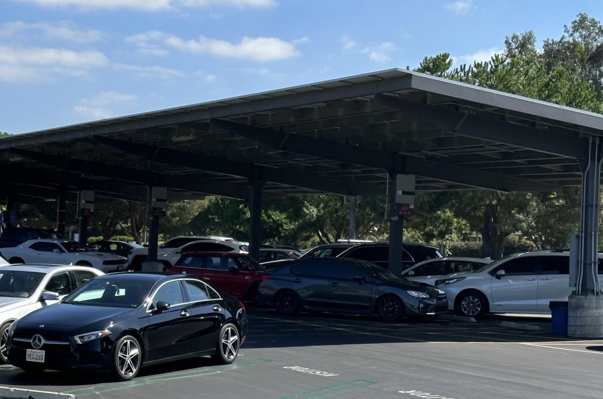 The University High School parking lot during the school day with cars parked and built-in solar panels.