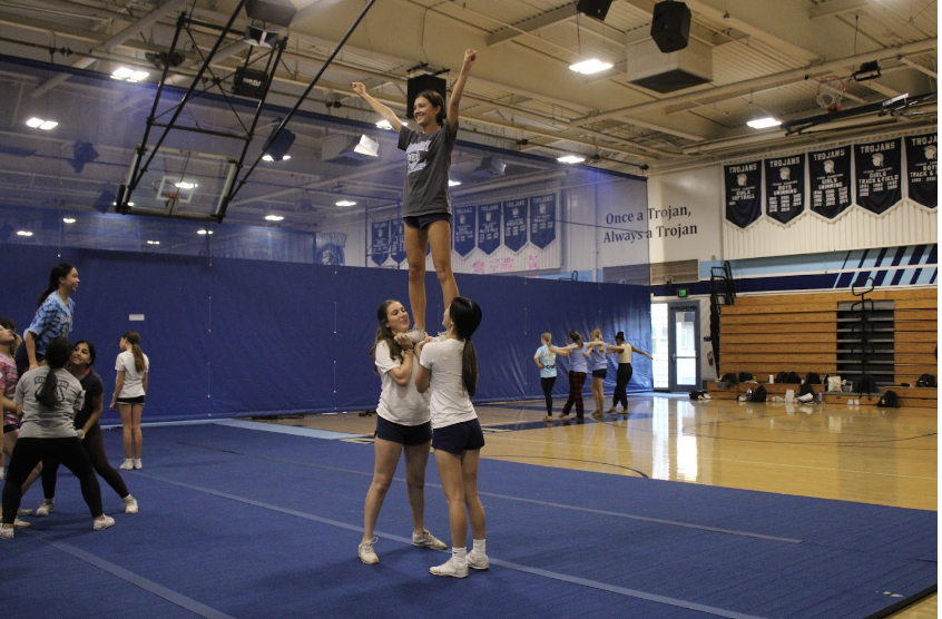 Varsity cheerleaders performing a half without a backspot. Bases Maddie DeBella and Chloe Tsai held up their flyer, Addison Lindenberg. 
