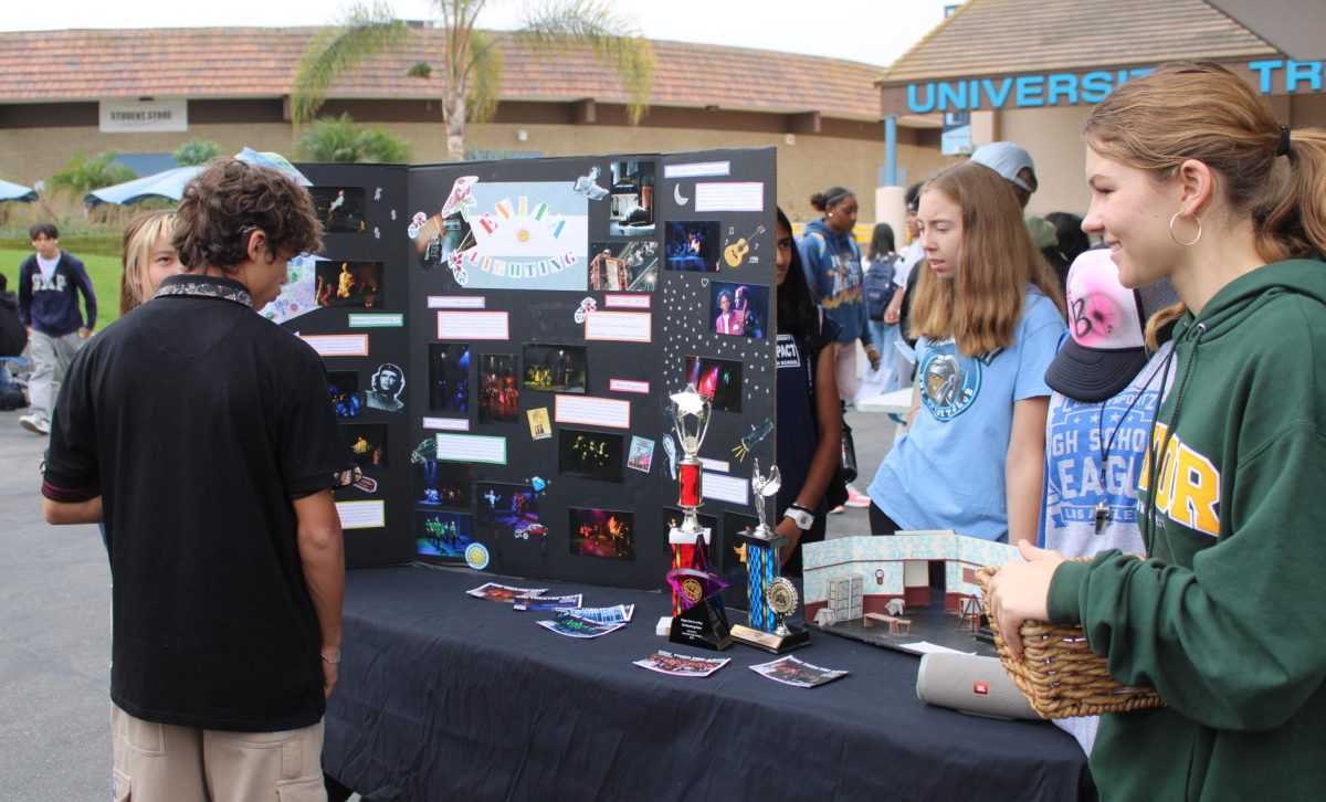 The UHS Drama Club booth interacted with students at their booth during the Freshman Club Showcase, sharing information about their club's mission and activities.