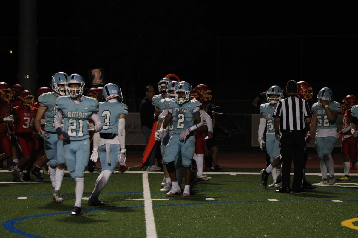 UHS Football rushing onto the field, preparing for the next play against the Woodbridge Warriors.