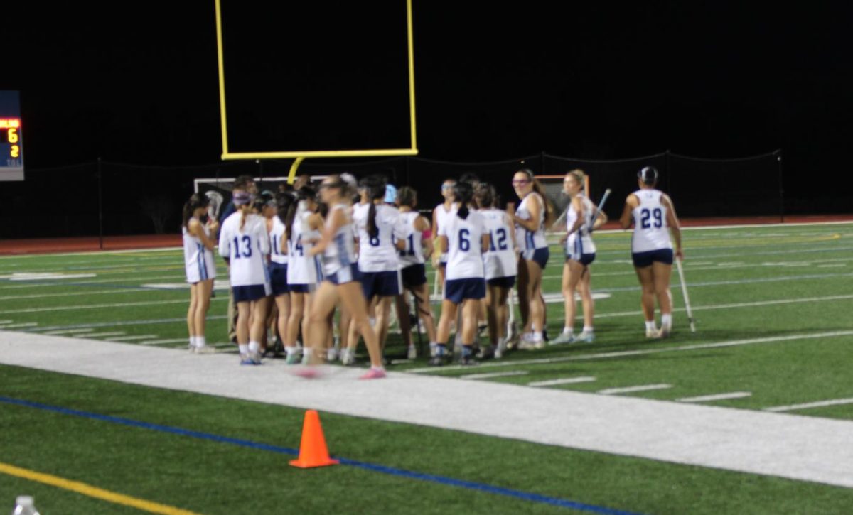 Trojans' Girls' Lacrosse reconvene mid-game.